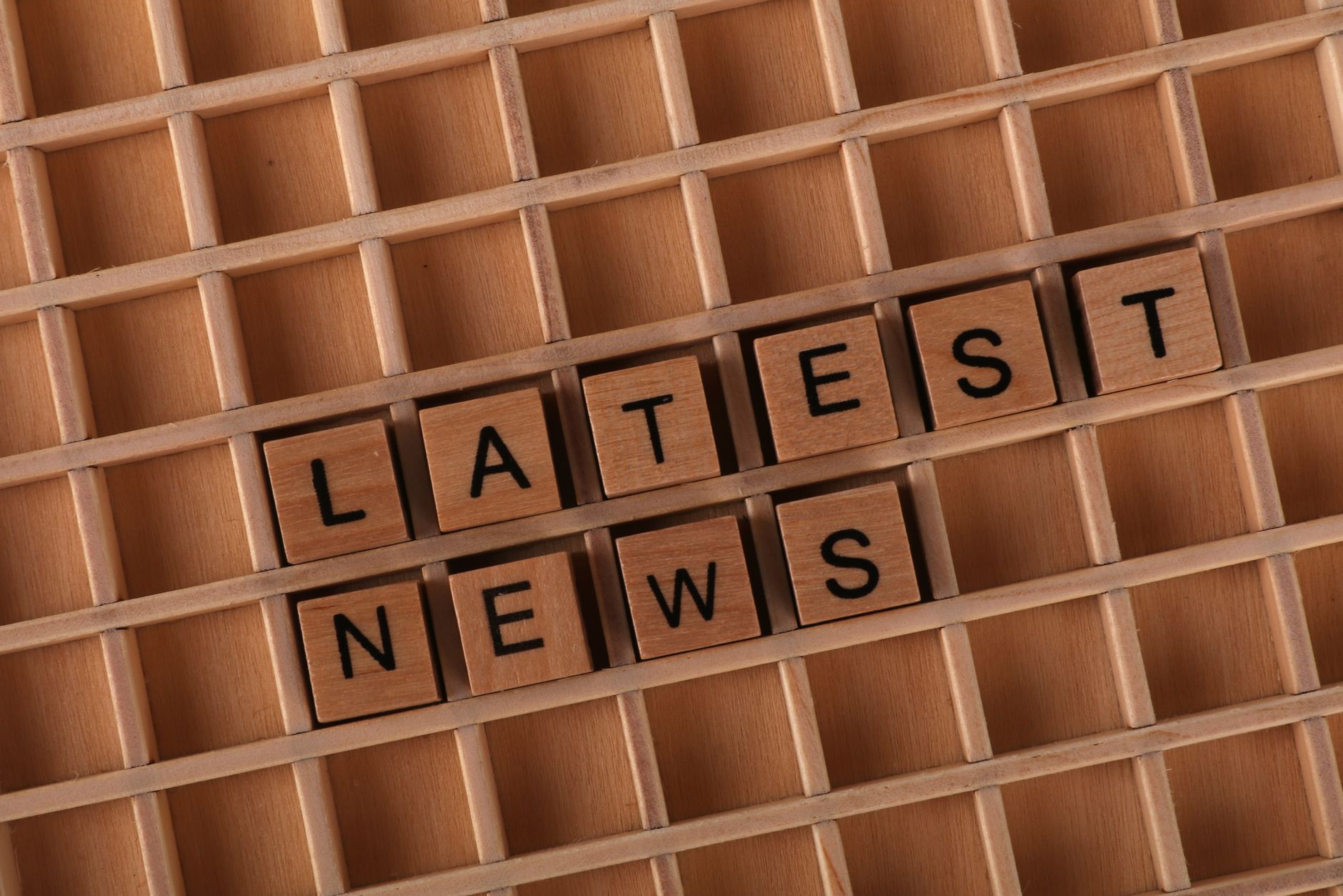 Wooden letter blocks spelling 'Latest News' on a grid surface. Ideal for media concepts. — Talismania Casino propose-t-il des
